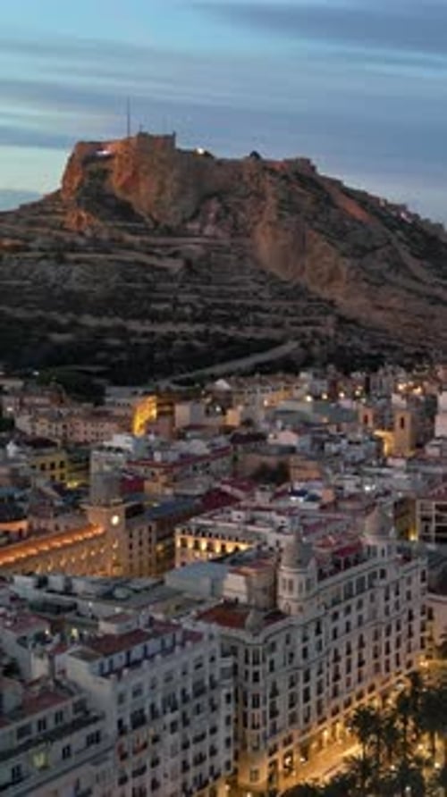 Aerial drone view of the Santa Barbara Castle on the coast of Alicante, Spain at sunset. Vertical