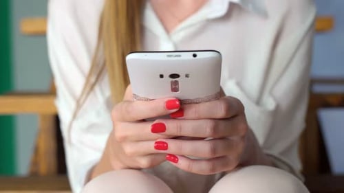 Girl In White Clothing Use Portable Gadget For Sending Message Online. 20s Sitting Home On The St...