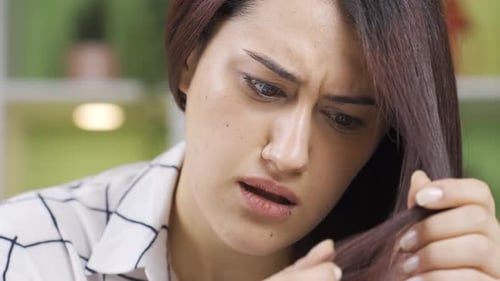 Beautiful Woman Examines Long Hair for Damage