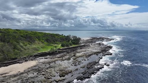 Aerial View of Rocky Coastline Meeting Turquoise Ocean