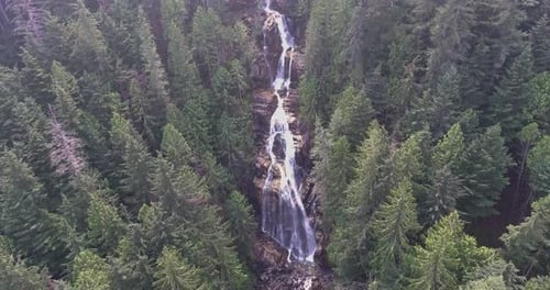Drone Shot Panning Up of a Mountain Waterfall Nestled in a Forest in 4K.