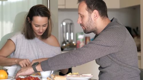 Happy Couple Eating Breakfast Together in Bright Kitchen