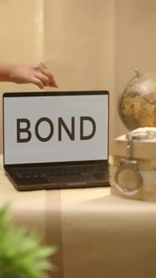 Hand Opens Laptop Displaying the Word BOND