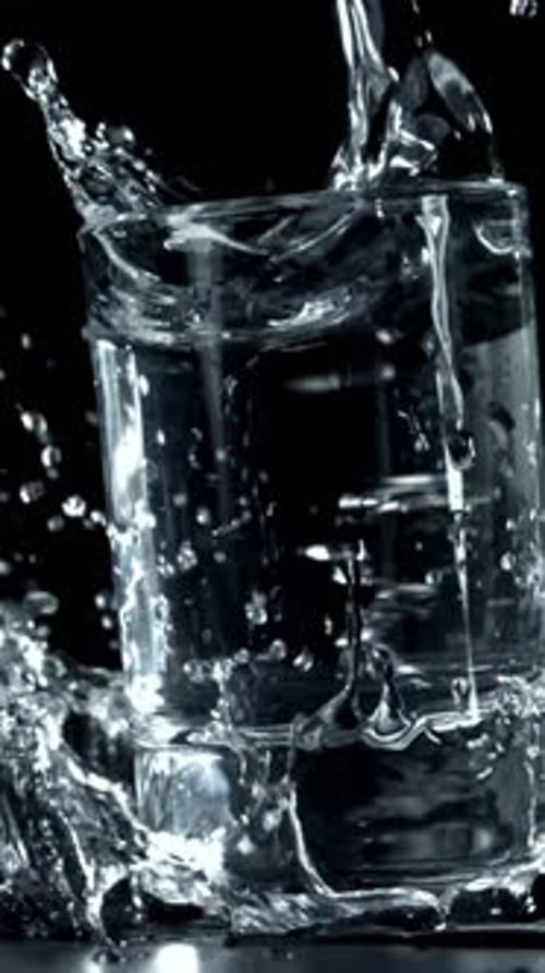 Wodka in einem Glas fällt auf den Tisch, gefilmt mit einer Hochgeschwindigkeitskamera mit 1000 Bildern pro Sekunde