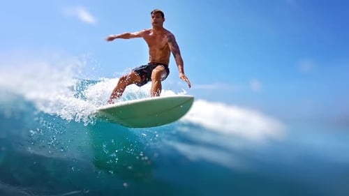 Young Male Surfer Rides the Ocean Wave in Maldives