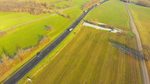 drone flight over open country road with some traffic