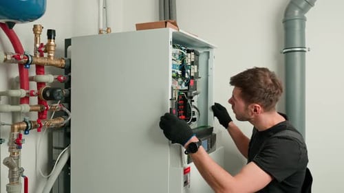 Man Repairing Electrical Panel in Utility Room
