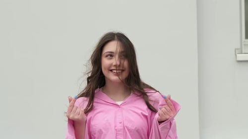 Uma jovem sorri brilhantemente enquanto faz gestos divertidos com as mãos, irradiando alegria e felicidade Este