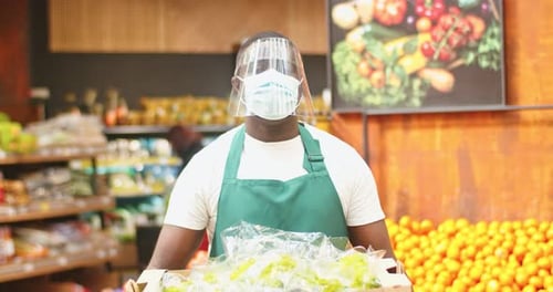 Strong Male Salesman Wearing Medical Mask and Protective Face Visor in Supermarket Adult Afro
