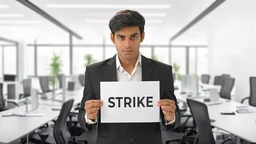 Man Holds Strike Sign in Modern Office