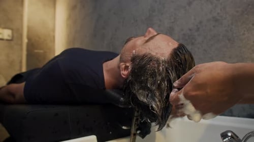Man Getting Hair Washed at a Salon