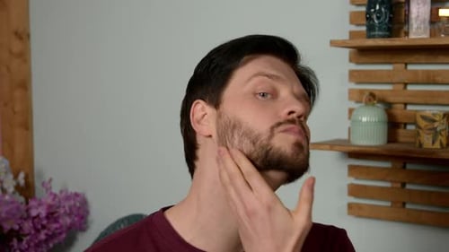 Man Applying Moisturizer to Face in a Bathroom