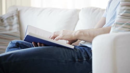 Close Up of Man Sitting on Couch and Reading Book at Home Activity