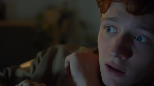 Face of Young Man Expressing Fear While Watching Horror Movie