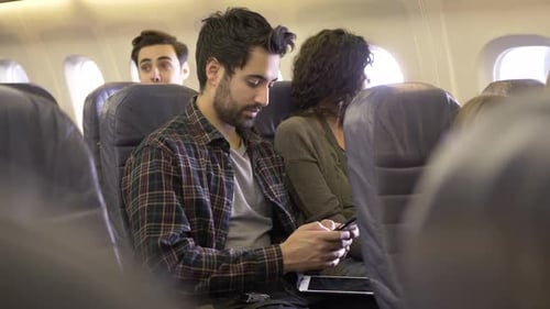Man Using Smart Phone In Airplane