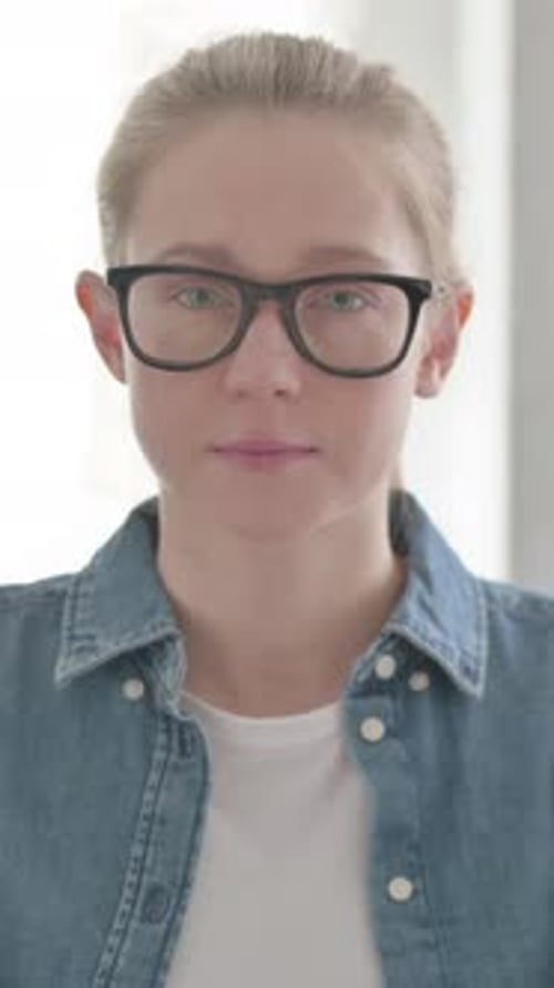 Porträt einer jungen Frau, die in die Kamera blickt, vertikales Video