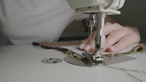 Une couturière travaille sur une machine à coudre dans un atelier