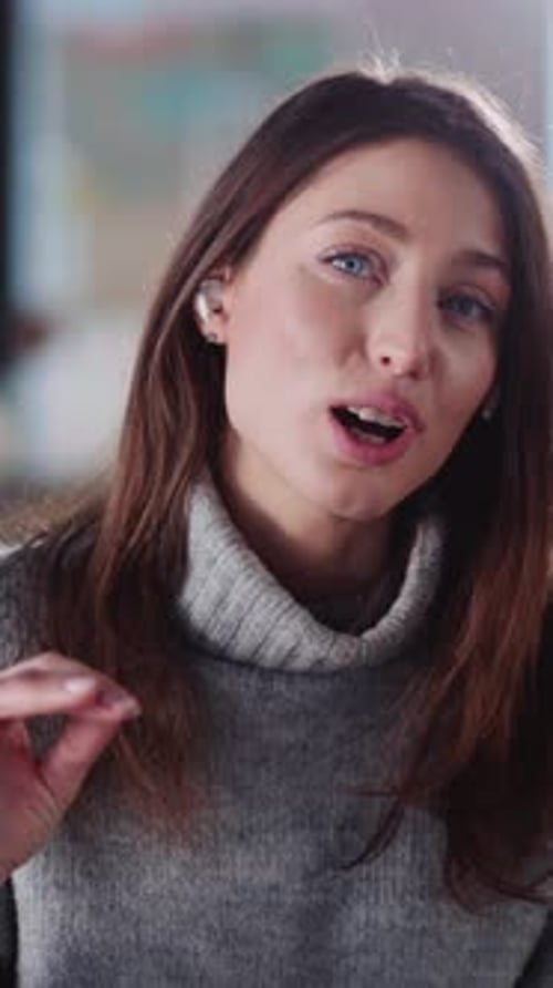 Young Woman Talking to Camera Wearing Earbuds