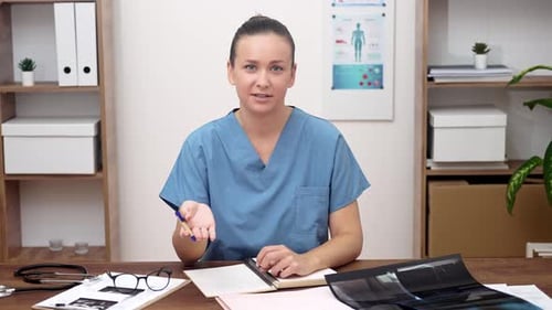 Woman in Scrubs Discusses Health at Her Desk