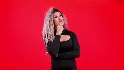 Contemplative Person with Makeup Posing on Red Background