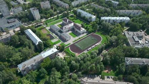 Aerial View of School Building and Sports Field in Residential District Clip