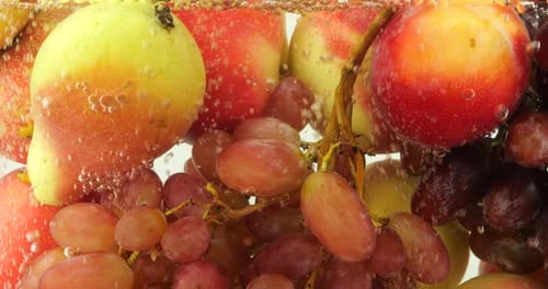 Background with fruits and berries in water with air bubbles.