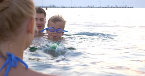 Family Playing with Swimming Toy in Sea