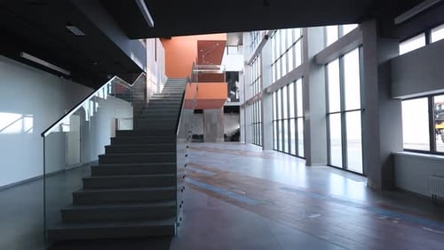 The Camera Pans Across a Spacious and Empty Hall Inside a Modern Office Building The Hall is Filled