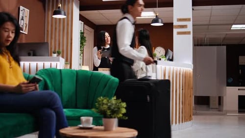 Hotel Receptionist Checks in Guest with Mobile Device