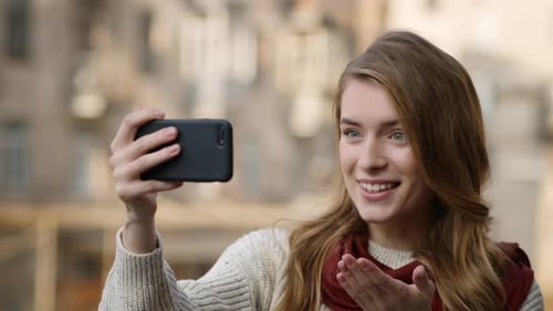 Smiling woman video calling with her smartphone