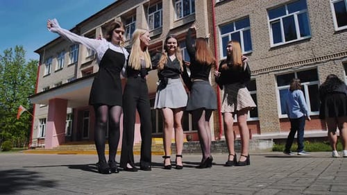 Estudantes felizes comemorando o final do ano letivo em frente ao prédio do ensino médio