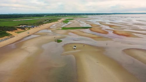 Aerial View of Beached Boat on Wide Sand Flats with Marsh Grass and Tide Pools