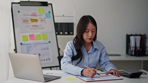 Businesswoman is working on laptop in office space.