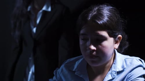 Woman Being Questioned in Dark Interrogation Room