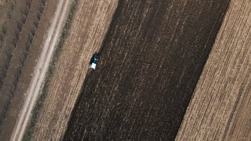Luftaufnahme eines Traktors, der Boden auf einem Feld pflügt