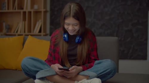 Teen Girl Using Smartphone on Couch at Home