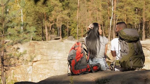 Hiking Couple Sits on the Edge of the Cliff