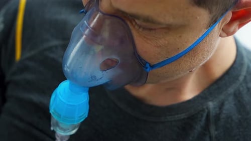 Homme en mauvaise santé portant un masque de nébulisation respirant à la maison, santé, équipement médical et concept de personnes