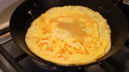 Omelet Frying in a Pan on Stove