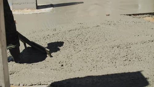 Construction Worker Smoothing Concrete with Tool Outdoors