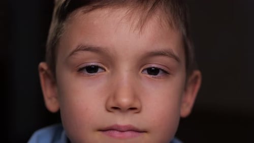 Child Stares Straight Ahead in Close Up Portrait