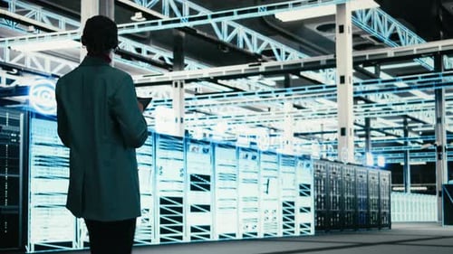 Female Programmer Walking in Data Center Using Tablet to Write Code
