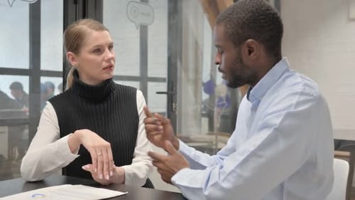 Woman and Man Talking at a Workplace Meeting