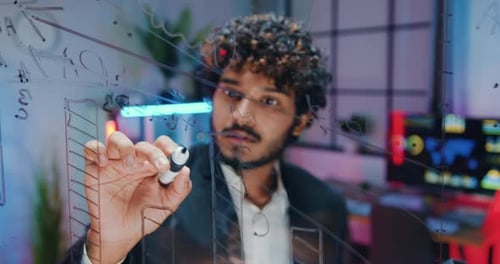 Man Drawing Graph on Transparent Display Board