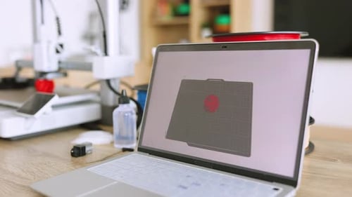 Laptop Displaying 3D Printer Design on a Wooden Desk