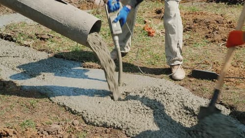 Der Arbeiter verdichtet den Beton mit einem Vibrator