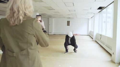 Woman Photographs Construction Manager in Modern Office