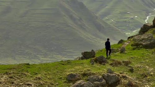 Imagens de drone de um homem caminhando no cume da montanha com vista panorâmica das terras altas