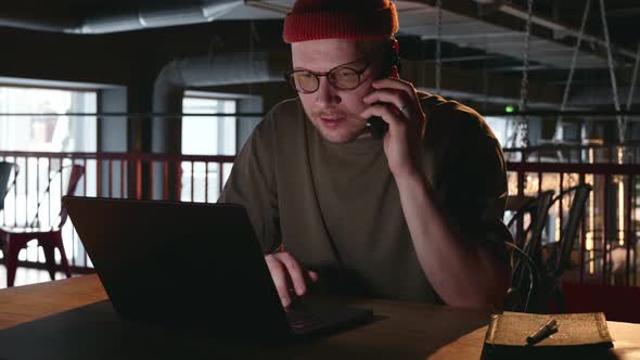 A Male Hacker Communicates on the Phone with a Person He is Trying to ...