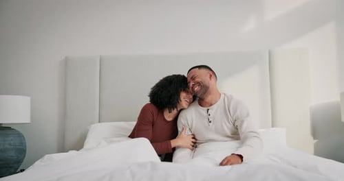 Happy Couple Laughing Together in Bed